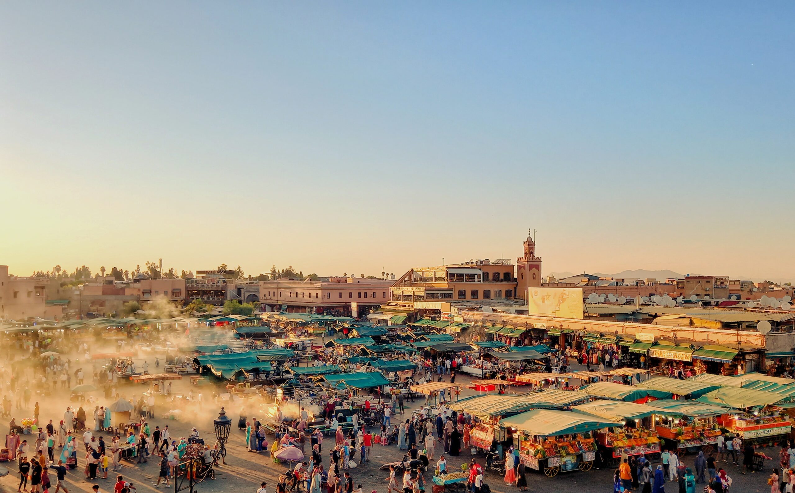 Plaza Jemaa el-Fna al anochecer con puestos de comida y artistas callejeros